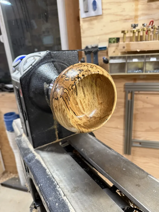 A wooden bowl taking shape on the lathe in the TorgCrafted workshop