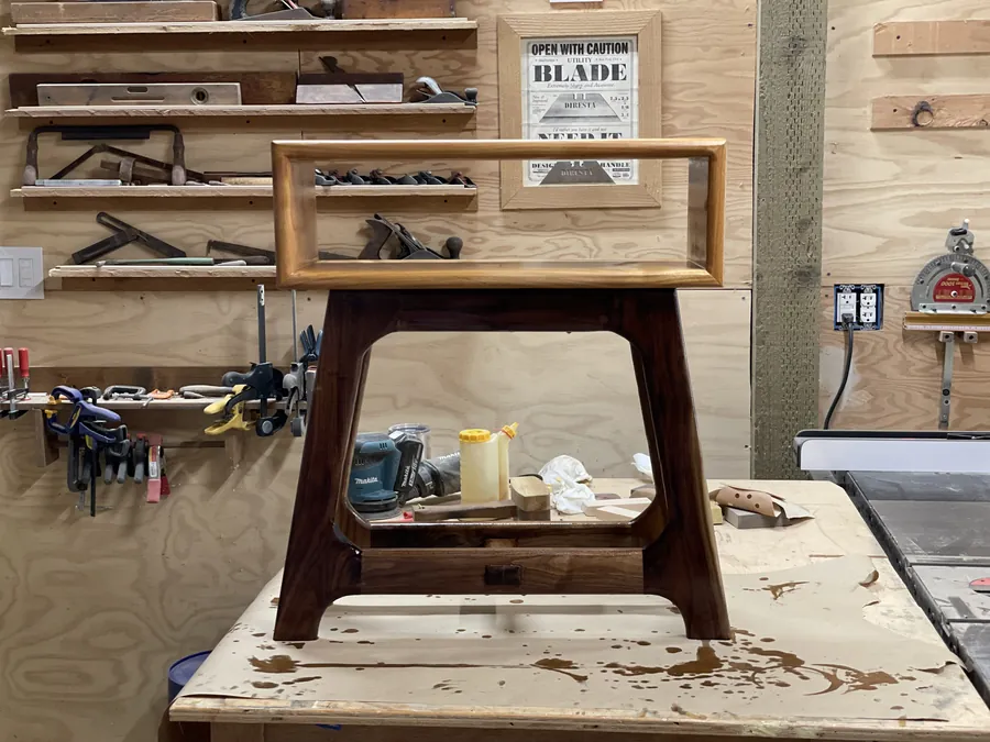 Handcrafted side table with tapered legs and a small drawer, in the workshop